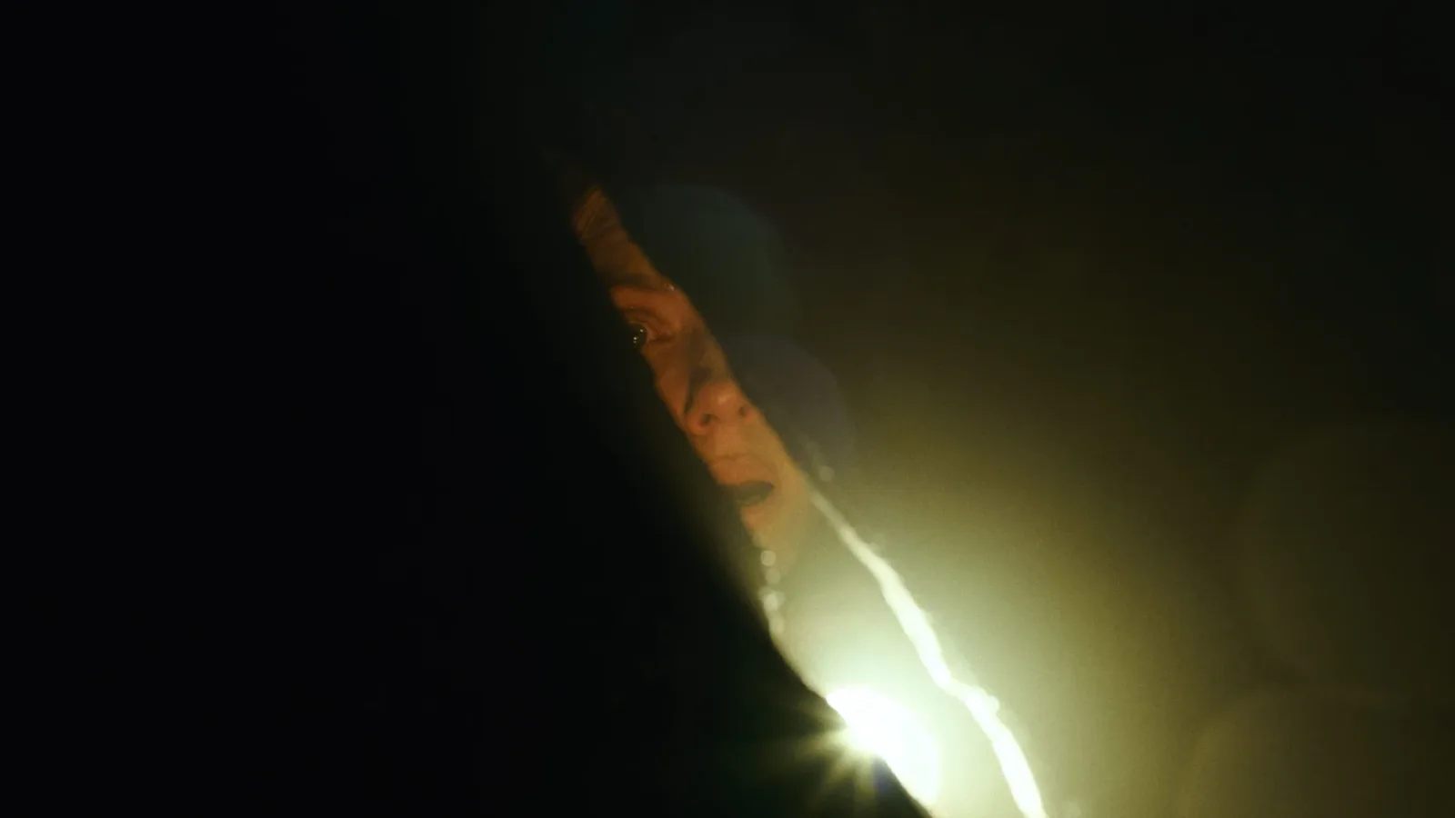 Light breaking into a dark room in The Exorcist: Martyrs, as otherworldly trouble reaches Detective Miller’s home