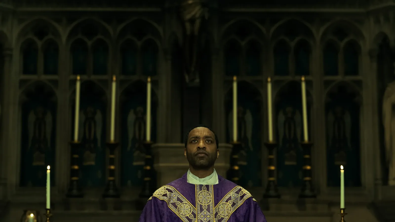 Chiwetel Ejiofor as Father William at the altar in The Exorcist: Martyrs